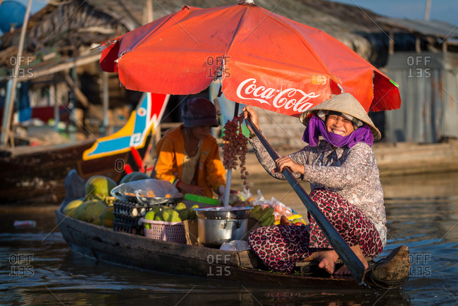 Floating Village, Kompong Chnang, Cambodia - 15 December 2014: Floating Shop Rows Past Houses In Warm Evening Light.