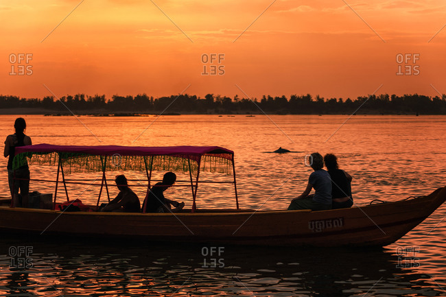 Dolphin Watching, Mekong River, Kratie Province, Cambodia - 31 January 2012: Tourist On Boat At Sunset See The Elusive Irrawaddy Dolphin.