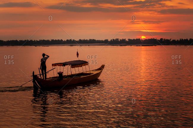 Dolphin Watching, Mekong River, Kratie Province, Cambodia - 31 January 2012: Local Dolphin Watch Boat Operator Watches Beautiful Sunset At End Of His Day.