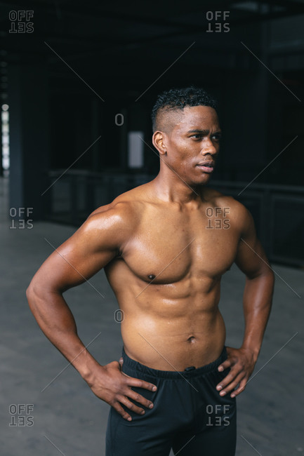 African American man standing and flexing his muscles in empty urban building. urban fitness healthy lifestyle.