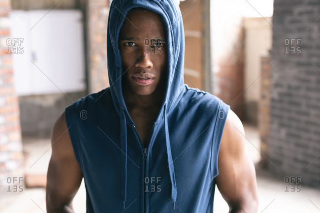 Portrait of African American man wearing hoodie looking at camera in empty urban building. urban fitness healthy lifestyle.