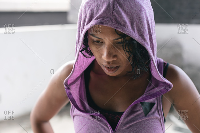 Portrait of African American woman wearing hoodie in empty urban building. urban fitness healthy lifestyle.