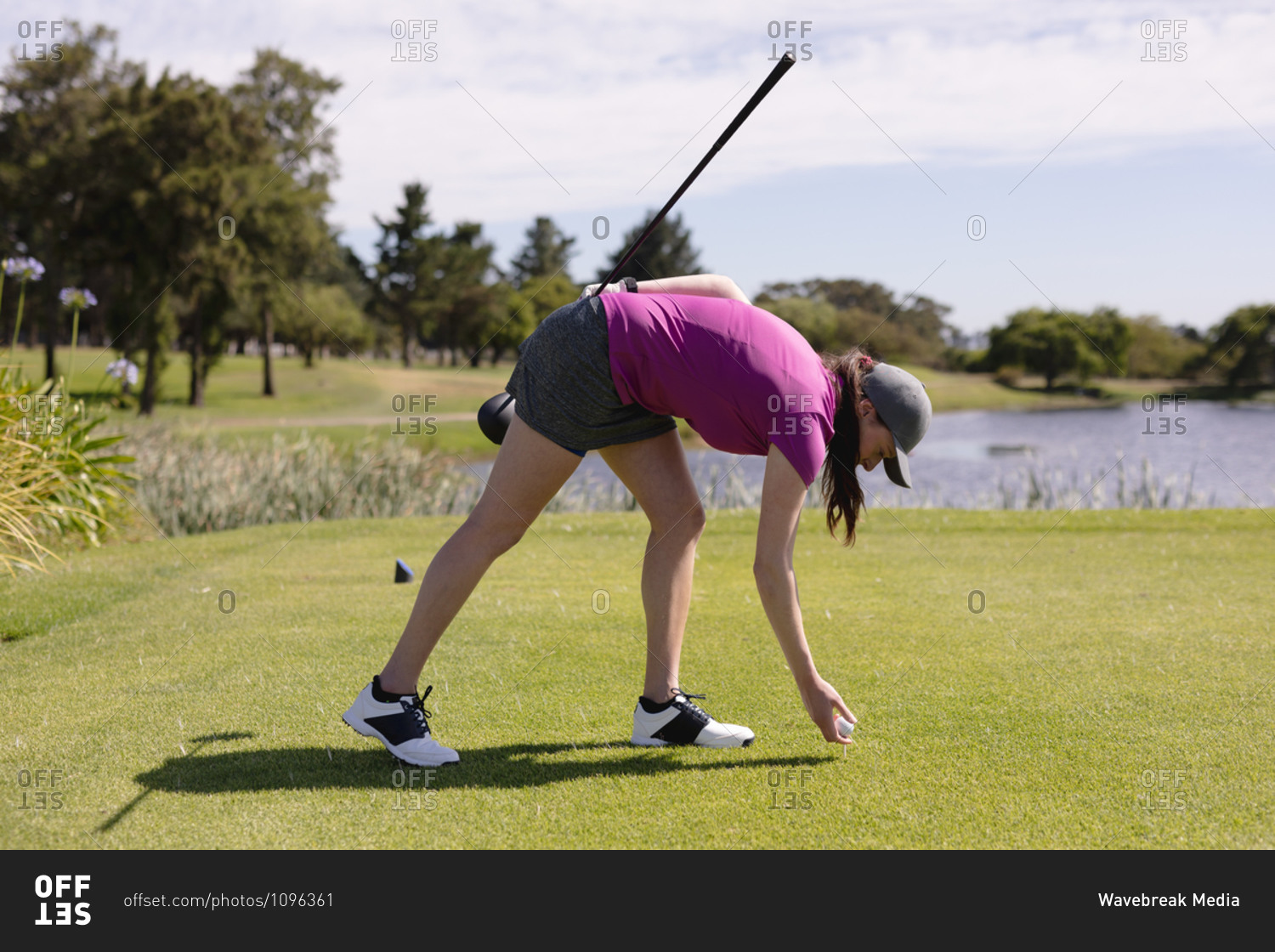 Caucasian woman playing golf placing the ball before taking a shot. sport leisure hobbies golf healthy outdoor lifestyle.