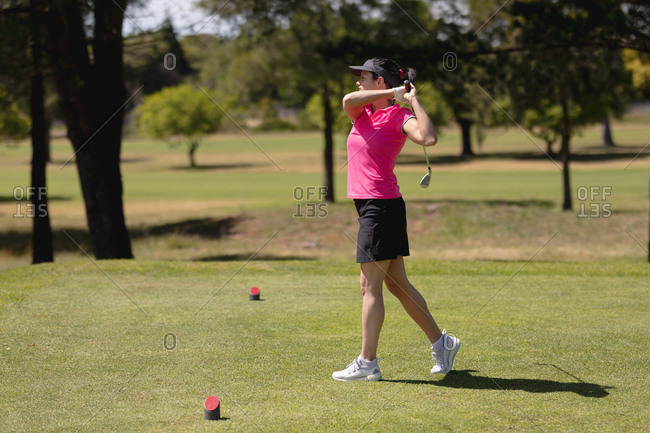 Caucasian woman practicing golf at golf course on a bright sunny day. sports and active lifestyle concept.