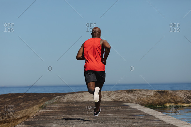 Young African-American black man jogging and running on a path and