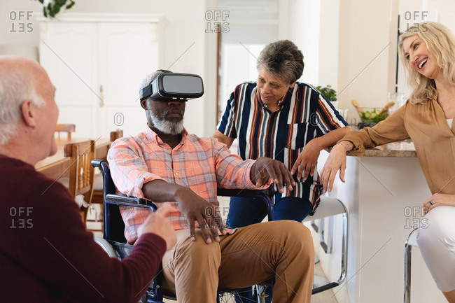 Senior caucasian and African American couples sitting on couch using vr headset at home. senior retirement lifestyle friends socializing.