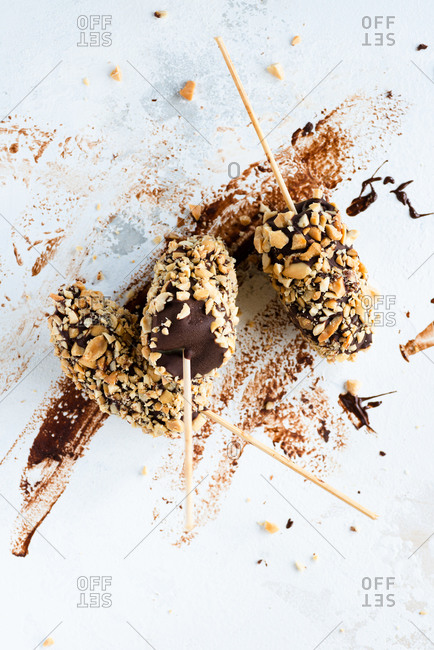 Bananas dipped in chocolate and nuts frozen dessert  top view