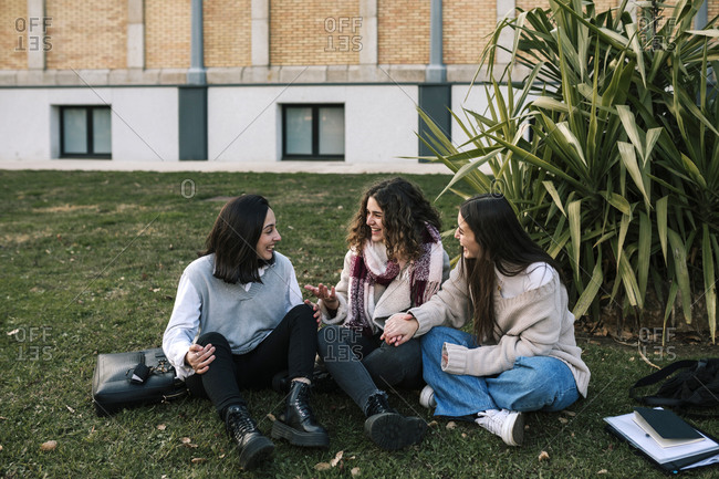 Three Caucasian female friends on the lawn of a college campus