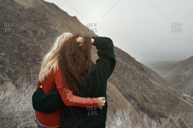 Two women hugging at the rocky mountains