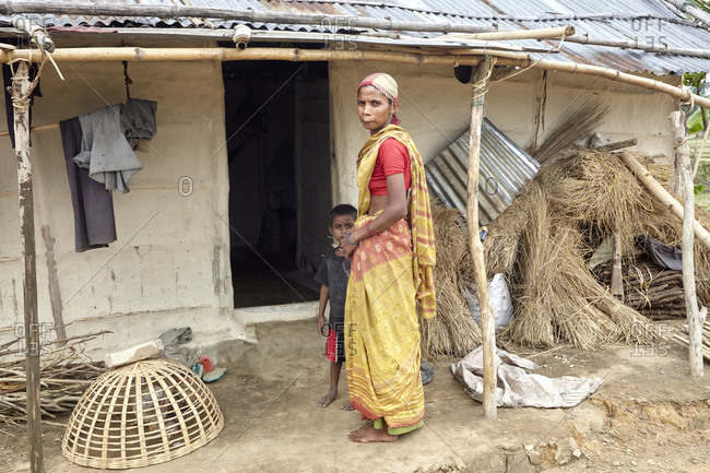 Bangladesh - April 30, 2013: A young woman with her boy in front of a poor house in rural Bangladesh