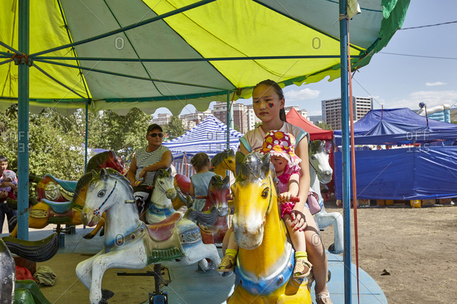 Ulaanbaatar, Mongolia - July 11, 2015: Children having fun at an amusement park during the National Naadam Festival