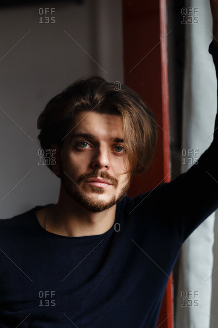 Young man with a beard and beautiful hair at home alone