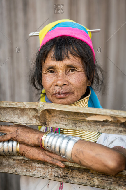 PADUANG PEOPLE, PAN PET VILLAGE, KAYAH STATE, MYANMAR - 28 January 2019: Portrait of local lady wearing brass coils placed around the neck, appearing to lengthen it, leaning on garden fence.