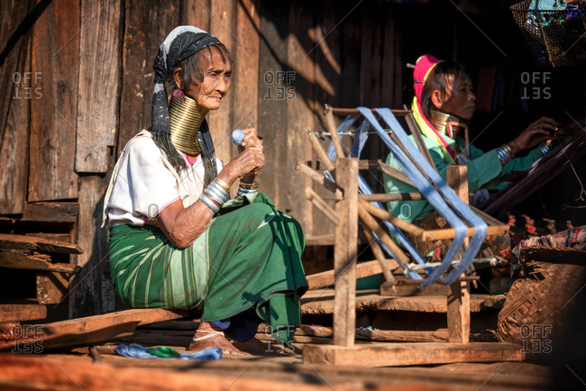 PADUANG PEOPLE,  HILL TRIBE, PAN PET VILLAGE, KAYAH STATE, MYANMAR - 24 January 2017: Portrait of old lady wearing brass coils placed around the neck, appearing to lengthen it, while refing cotton.