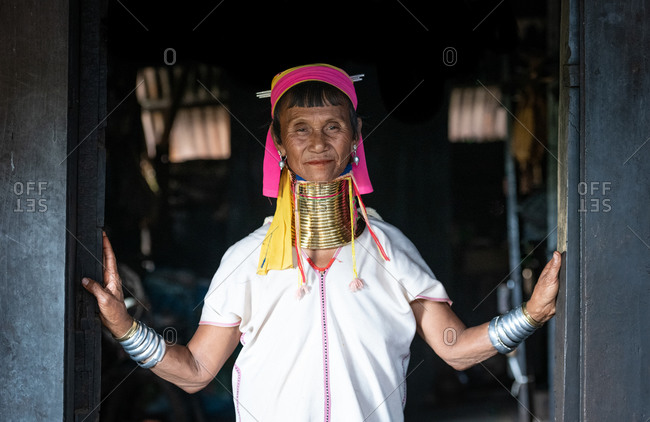 PADUANG PEOPLE,  HILL TRIBE, PAN PET VILLAGE, KAYAH STATE, MYANMAR - 28 January 2019: Portrait in doorway of local lady wearing brass coils placed around the neck, appearing to lengthen it.