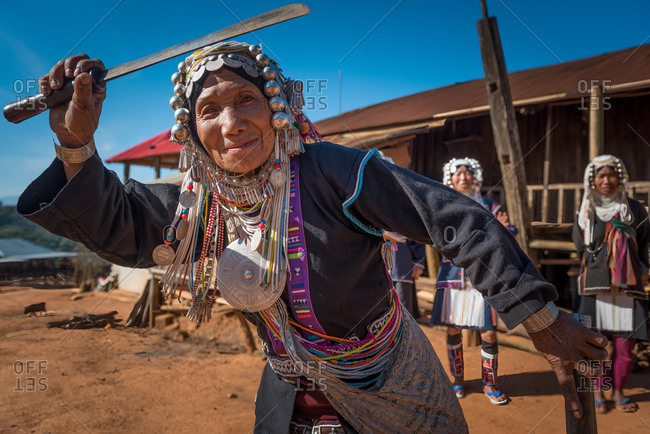 AKHA HILL TRIBE, HOKYIN VILLAGE, MYANMAR - 18 January 2017: Women in traditional dress dances with her knife in village square as part of musical performance.