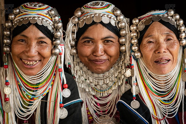 AKHA HILL TRIBE, HOKYIN VILLAGE, MYANMAR - 22 January 2019: Close up portrait of three hill tribe women in traditional dress and decorated head dress.