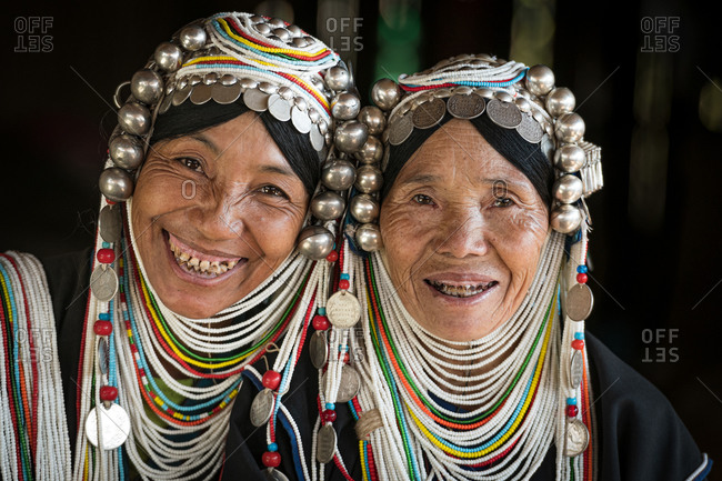 AKHA HILL TRIBE, HOKYIN VILLAGE, MYANMAR - 22 January 2019: Close up portrait of two hill tribe women in traditional dress and decorated head dress.
