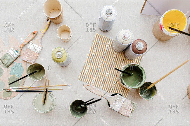 Top view of various paint and brushes placed on table in creative workshop