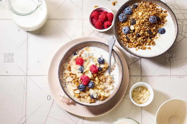 Flat lay with a bowl of granola with nuts and oats served with berries and milk