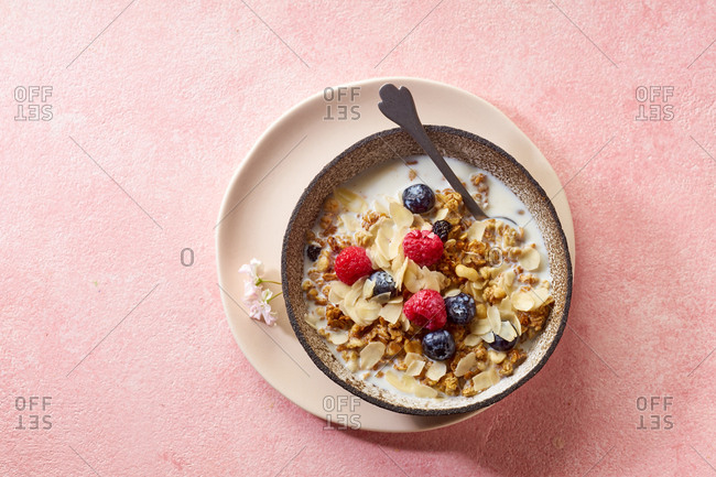 Top view of tasty breakfast with granola, berries and milk