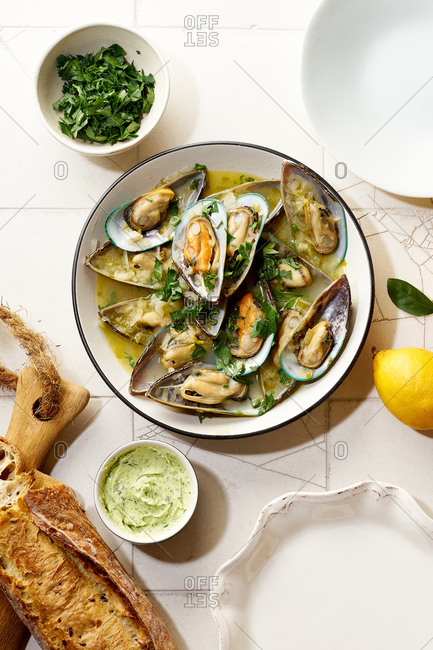 Cooked kiwi green mussels with wine, garlic and parsley served with baguette and butter with herbs