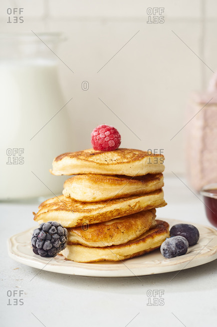 Fluffy breakfast pancakes with maple syrup and berries