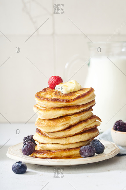 Fluffy breakfast pancakes with maple syrup and berries