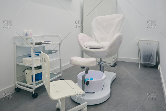 Interior of room for pedicure with medical chair and various equipment in modern beauty clinic
