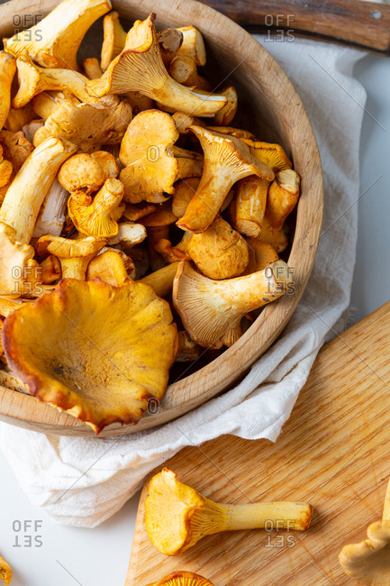 Overhead view of wild mushrooms in wooden bowl