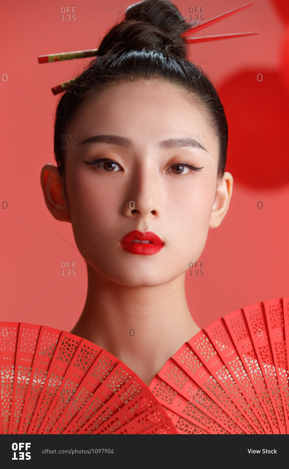 Beautiful female Chinese model posing in red against a backdrop of red lanterns