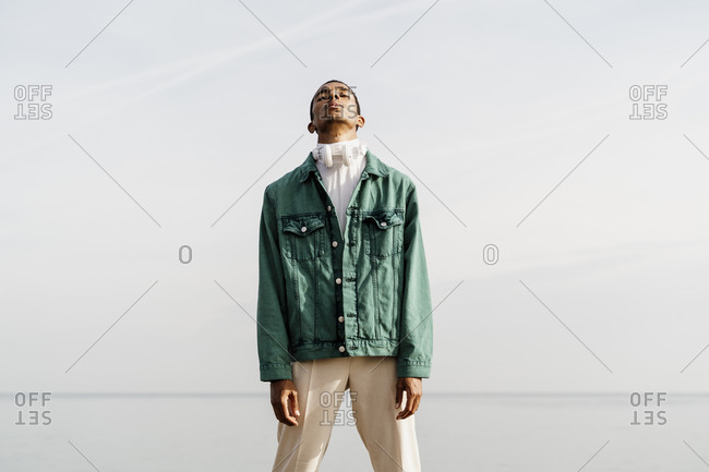 Young African man standing against sky and sea