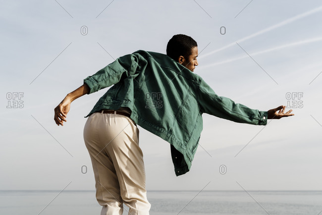 Carefree man dancing against sea and sky