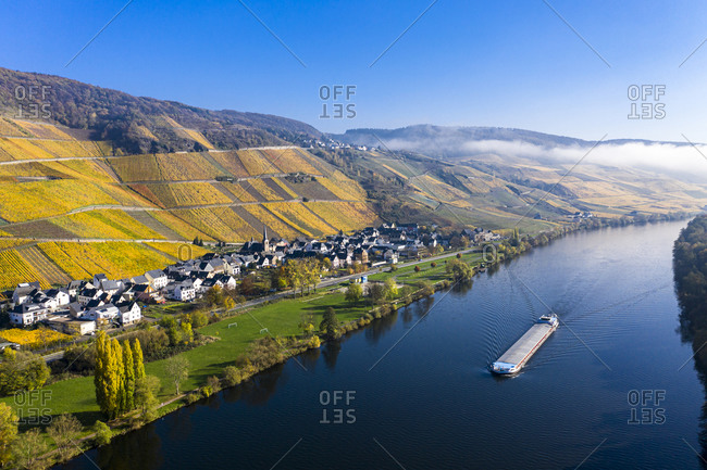 Germany- Rhineland-Palatinate- Bernkastel-Kues- Helicopter view of barge sailing along Middle Moselle with rural town in background