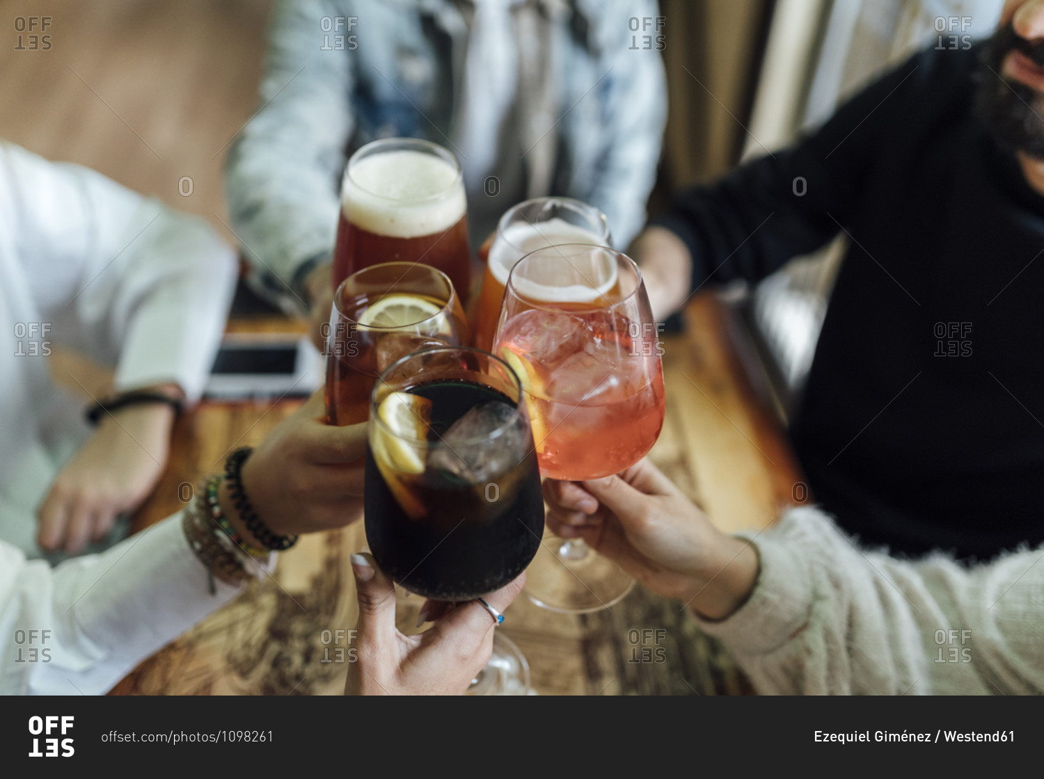 Friends hands toasting glasses at bar