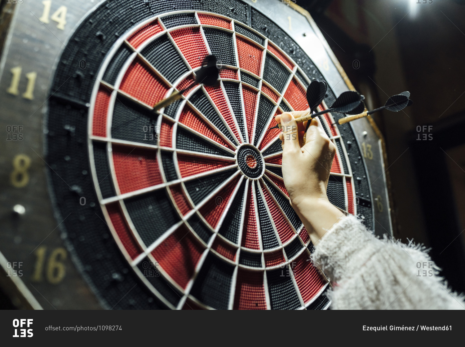 Woman\'s hand collecting darts from board