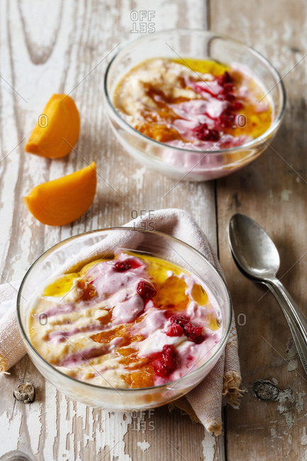 Two bowls of curd cheese raspberries and persimmons