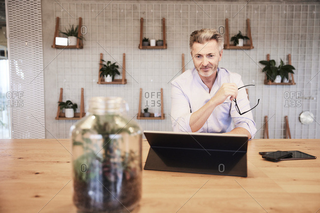 Smiling businessman using digital tablet while sitting at home
