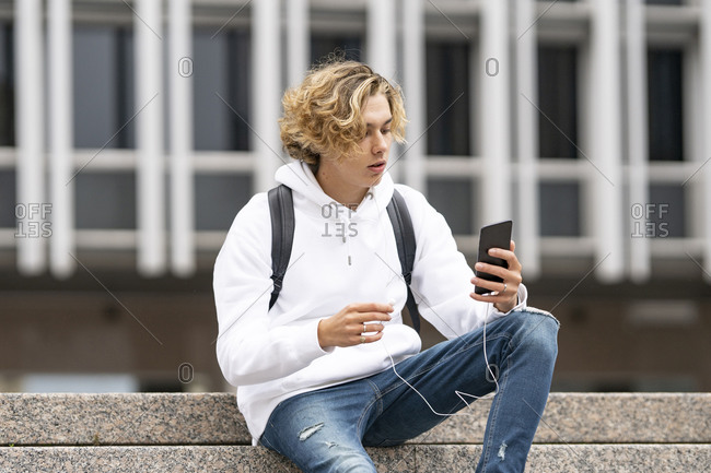 Young man using mobile phone while sitting on staircase
