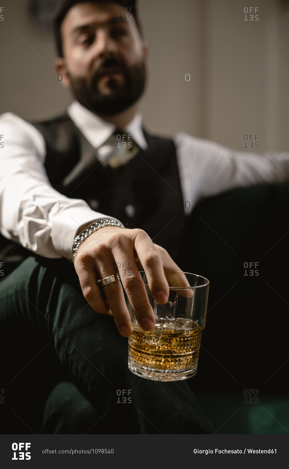 Arm of man holding glass of whiskey