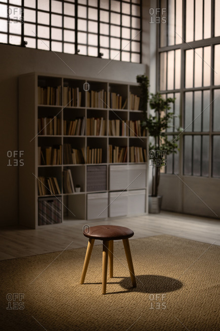 Empty stool with bookshelf behind