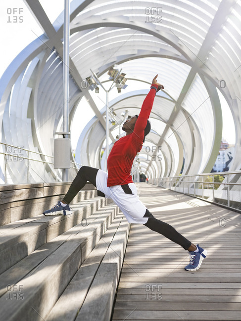 Male acrobat stretching while exercising on walkway