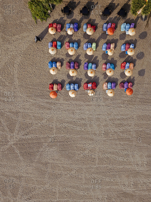 Aerial view of rows of umbrellas and deck chairs on empty Kuta Beach- Bali- Indonesia