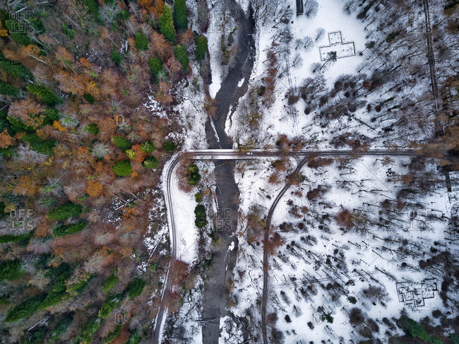 Aerial view of country road stretching through snow-covered landscape