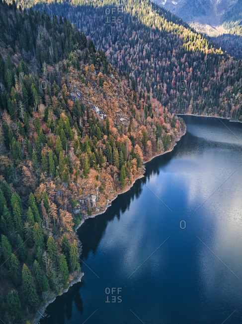 Aerial view of forested shore of Lake Ritsa in autumn