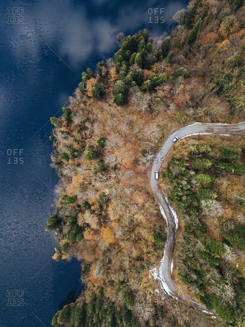 Aerial view of country road winding along shore of Lake Ritsa in autumn