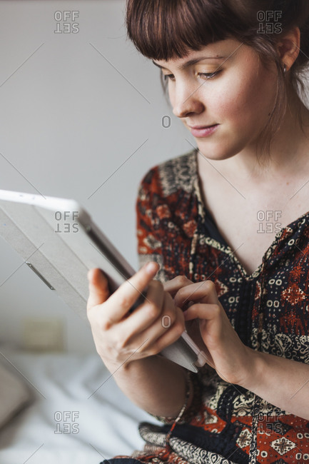 Woman learning online tutorial on digital tablet at home