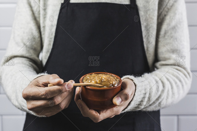 Mid section of man holding bowl of homemade date cream