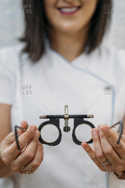 Smiling female optometrist with eyeglasses in clinic