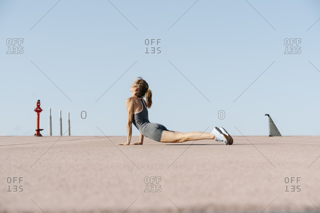 Female sports person practicing yoga against clear sky